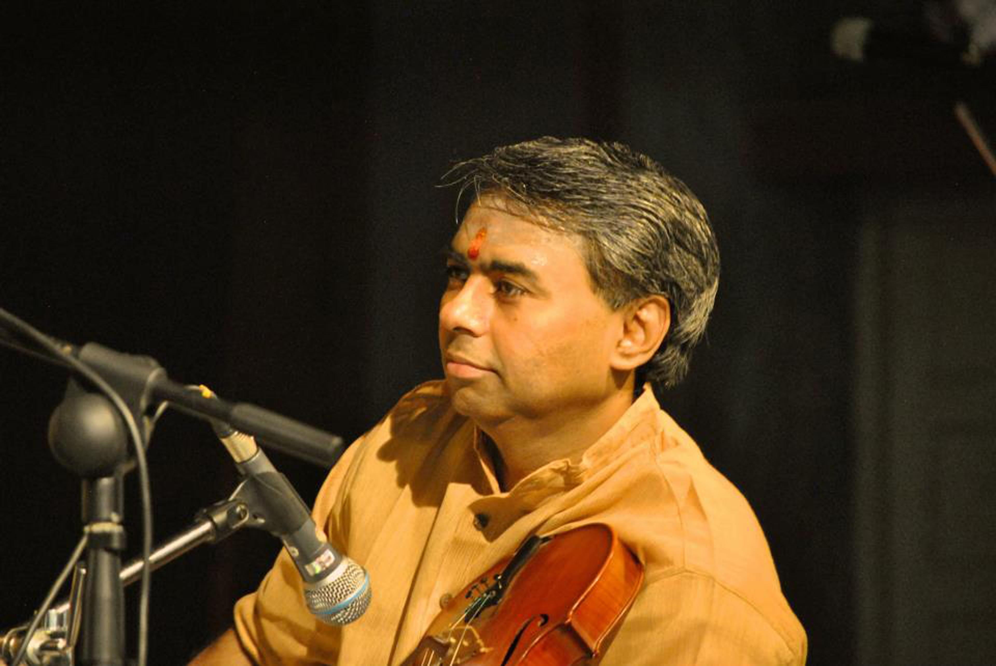 R. K. Shriramkumar seated with violin