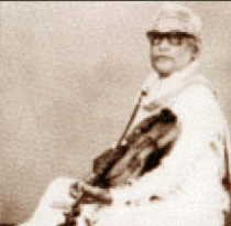 V. Lakshminarayana seated with violin